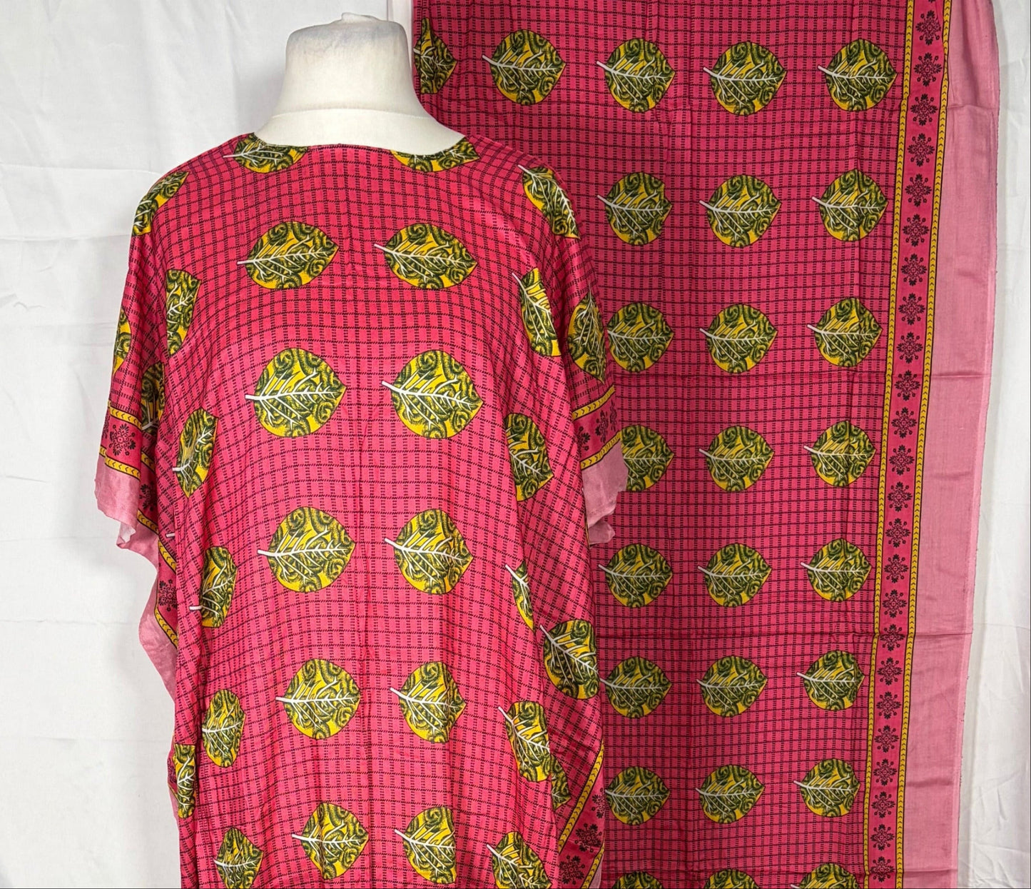 Red and green patterned fabric on a white surface with a wooden floor background