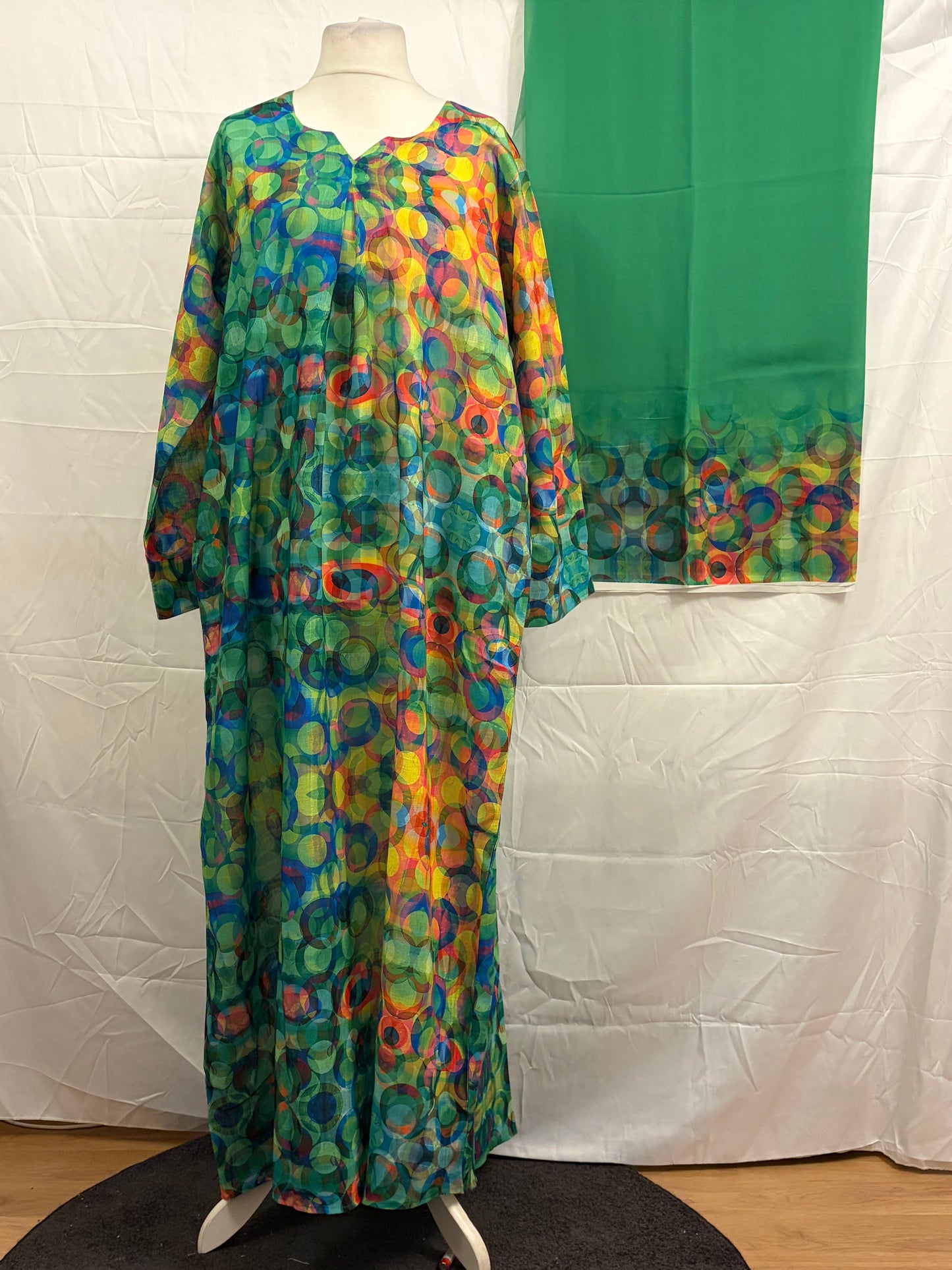 Colorful patterned dress on a mannequin against a white backdrop