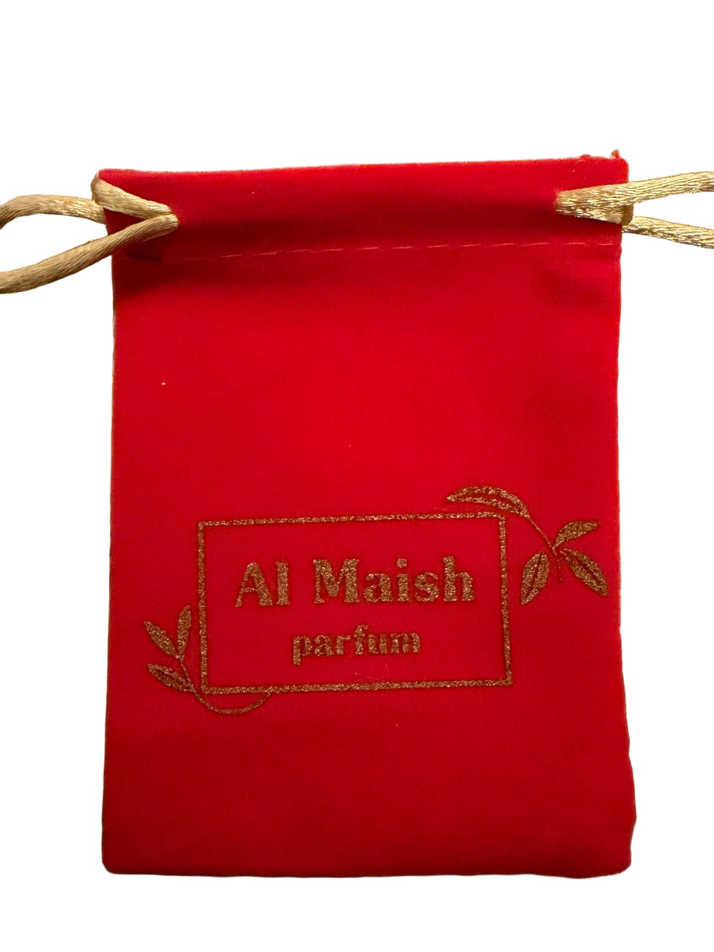 A small red drawstring pouch with a gold-embroidered logo reading 'Al Maish parfum' and gold leaf motifs, resting on a light wood surface.